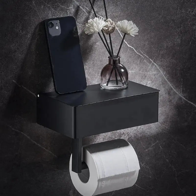 Black Elegance Guard: A sophisticated matte black toilet roll holder featuring a smart storage compartment. Luxinsly